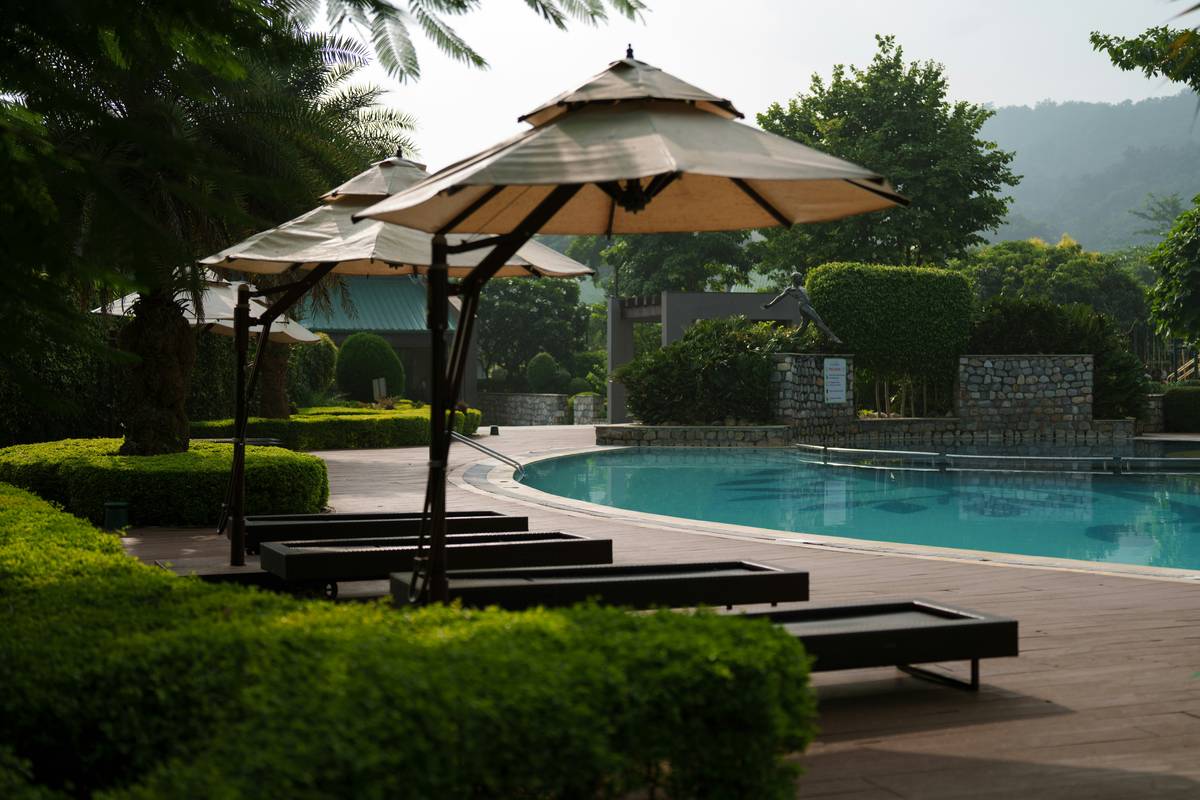 Sturdy poolside umbrellas with stand on a sloped patio resisting strong wind